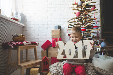 Smiling boy near fashion xmas tree
