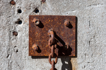Rusty ring-mount circuit on a concrete wall