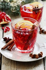 Winter sangria oder mulled wine :traditional drinks with spicy,citrus fruits and pomegranate . Rustic style.Selective focus 
