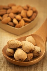 Almonds on brown wooden background