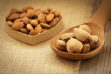 Almonds on brown wooden background