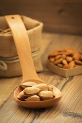 Almonds on brown wooden background