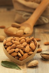 Almonds on brown wooden background