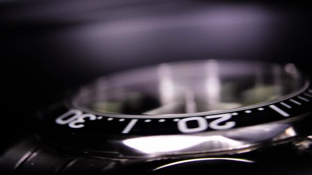 Extreme close-up of black luxury watch spinning in a watch winder