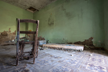 room in the house destroyed with only a chair and mattress