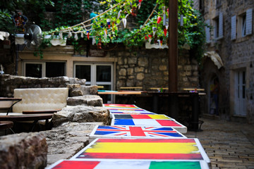 Fototapeta na wymiar Tables in street cafe, painted in colors of flags of different countries.