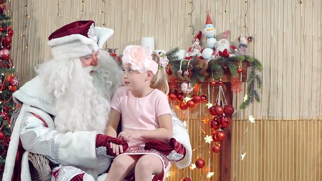 Santa Claus talking to a little beautiful girl.