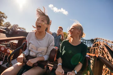Fotobehang Amusementspark Jonge vrienden op spannende achtbaanrit