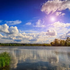 Obraz premium Wonderful landscape. Fantastic view. the overcast sky, heavy storm clouds over the water. Dramatic, beautiful scene in the evening on the lake in the woods. Beauty in the world