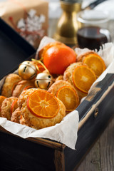 Christmas cookies with sliced tangerines and Christmas toys in a dark box. Selective focus.