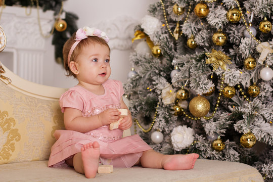 Baby girl near luxury christmas tree