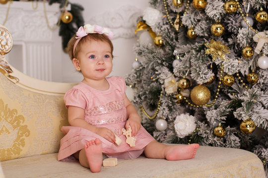 Baby girl near luxury christmas tree