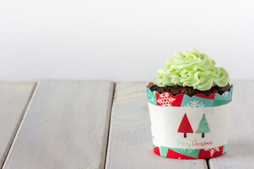 Chocolate Christmas Cupcake with Green Frosting on Light Background Horizontal