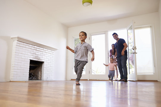 Excited Family Explore New Home On Moving Day