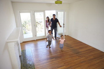 High Angle View Of  Family Exploring New Home On Moving Day