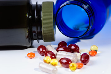 Many pills and tablets isolated with bottles on white background