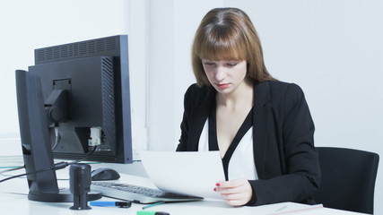 Pretty young woman excited after reading a document