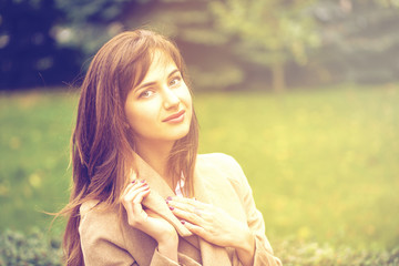 Portrait of a young beautiful woman in beige coat