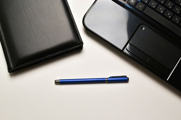 laptop, notebook and pen