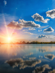 breathtaking scenery. Blue sky with clouds. reflection in water, for design .Colorful sunset with a halo of sunlight. picturesque scene. use as background