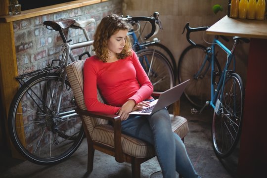 Woman sitting on chair and using laptop