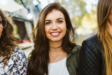 Beautiful young woman looking at camera in the street.