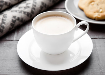 Cup of cappuccino with grey wool scarf and cookies