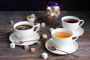 Tea, black tea, green tea, steaming black espresso coffee in white porcelain cups on rustic wooden...