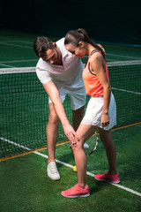 Obraz premium Professional bearded tennis instructor working with young woman