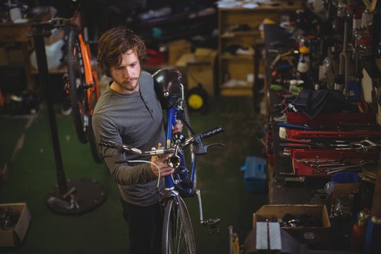 Mechanic carrying a bicycle