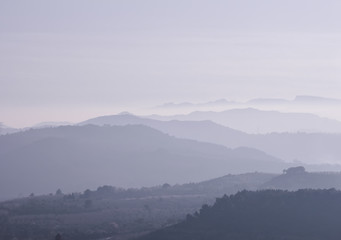 Mountains covered with heavy purple fog at sunset.