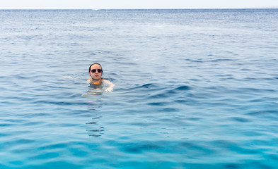 Young girl is swimming in the beautiful and clean sea
