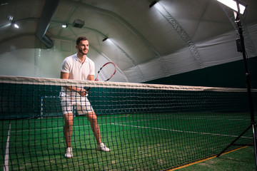 Positive handsome player playing tennis