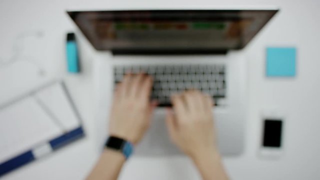 Blurred view of man typing on a laptop and showing thumbs up