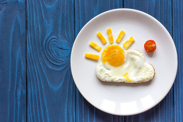 sunshine fried eggs breakfast for kid on blue background - obrazy, fototapety, plakaty