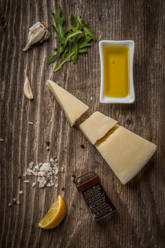 Parmesan cheese and grater with lemon olive oil and garlic on wood kitchen table