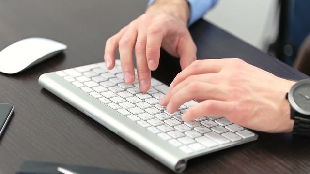 Man's hands typing on computer keyboard
