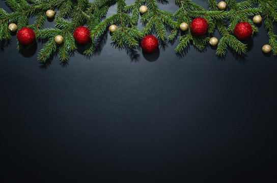 Christmas decoration background over black chalkboard, top view. Horizontal photo of decorations taken from above with copy space for text and other web or print design elements.