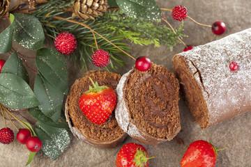 Sliced frosted chocolate yule log with strawberries at christmas
