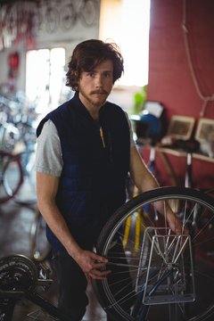 Portrait of mechanic examining bicycle