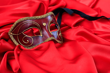 Carnival mask on red satin background