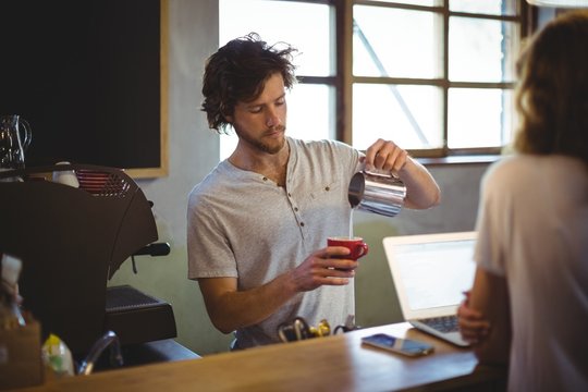 Mechanic preparing coffee at counter