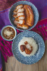 deep fried pork with sticky rice on thai fabric and old wooden,