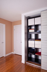 Fototapeta na wymiar Built-in closet with sliding door shelving storage organization
