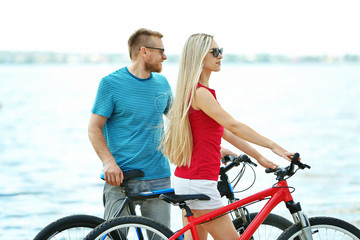 Obraz premium Happy couple with bicycles on the beach