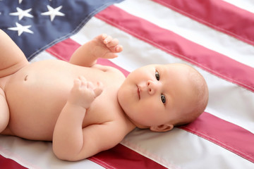 Small cute baby girl on USA flag background
