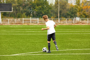 Boy playing football at stadium