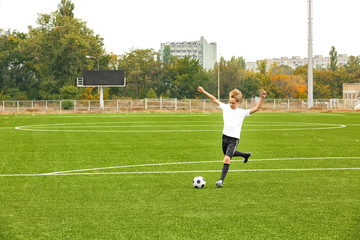 Boy playing football at stadium