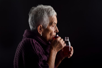 Old woman taking syrup