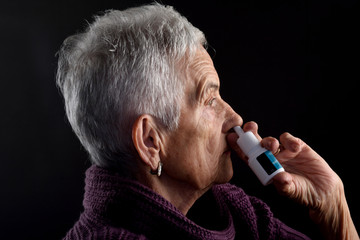 Old woman with nasal spray